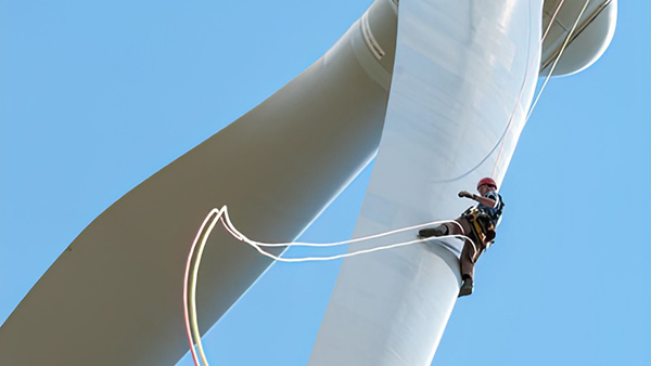 Operario realizando una reparación de palas en un aerogenerador