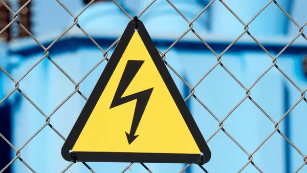 Señal de peligro eléctrico instalada en una valla que protege un transformador eléctrico