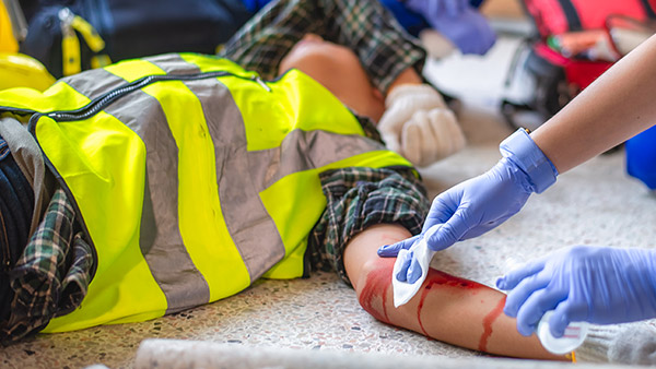 Asistencia médica a un trabajador lesionado en un brazo. EFA - Enhanced First Aid