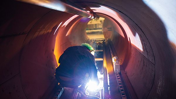 Trabajador realizando trabajos de soldadura en un espacio confinado. Espacios Confinados ATEX