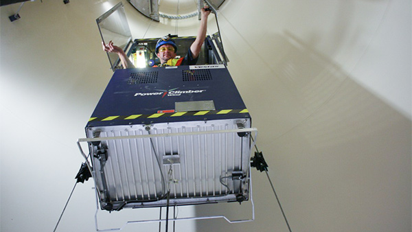 Operario utilizando un elevador situado dentro de la torre de un aerogenerador. Seguridad en Elevadores