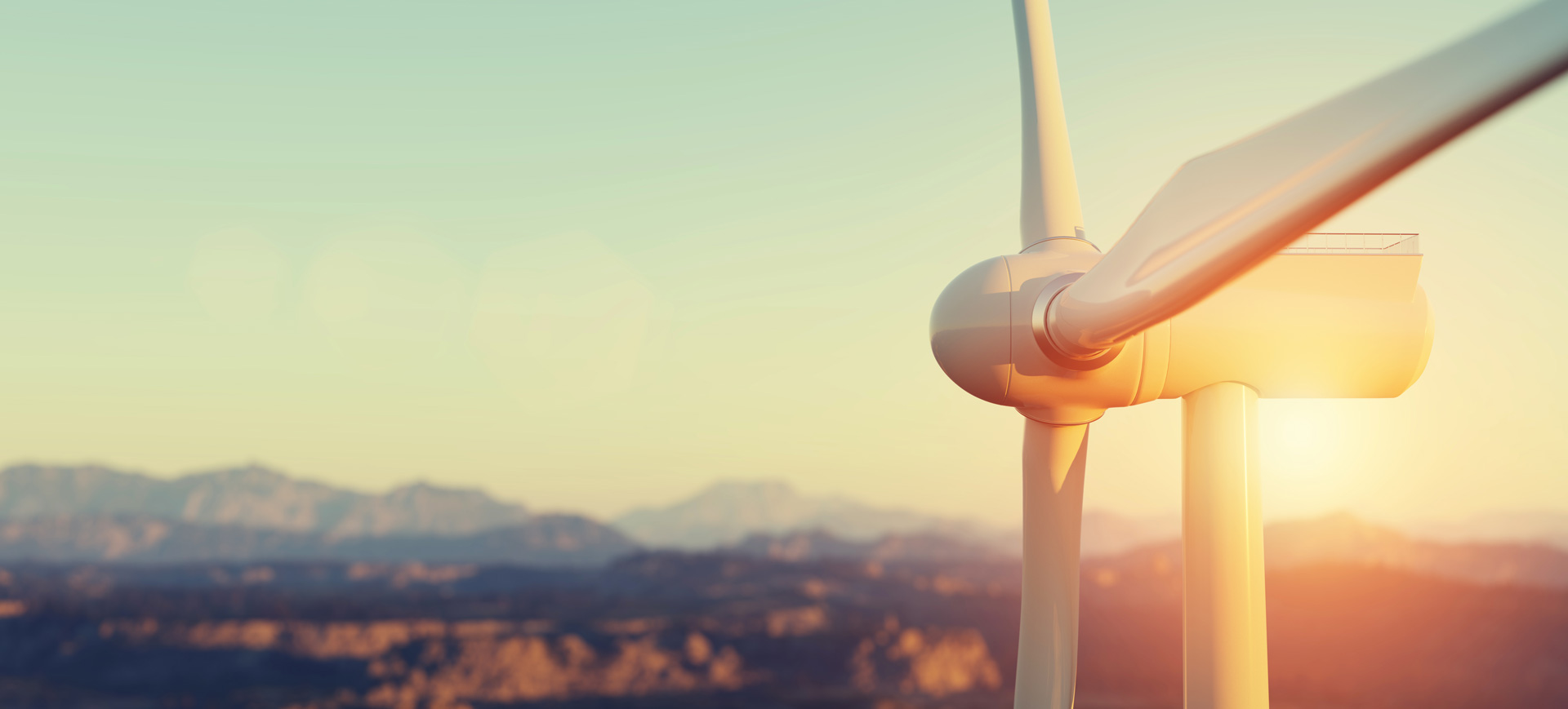 fotografía de una turbin a de un aerogenerador con el amanecer detrás